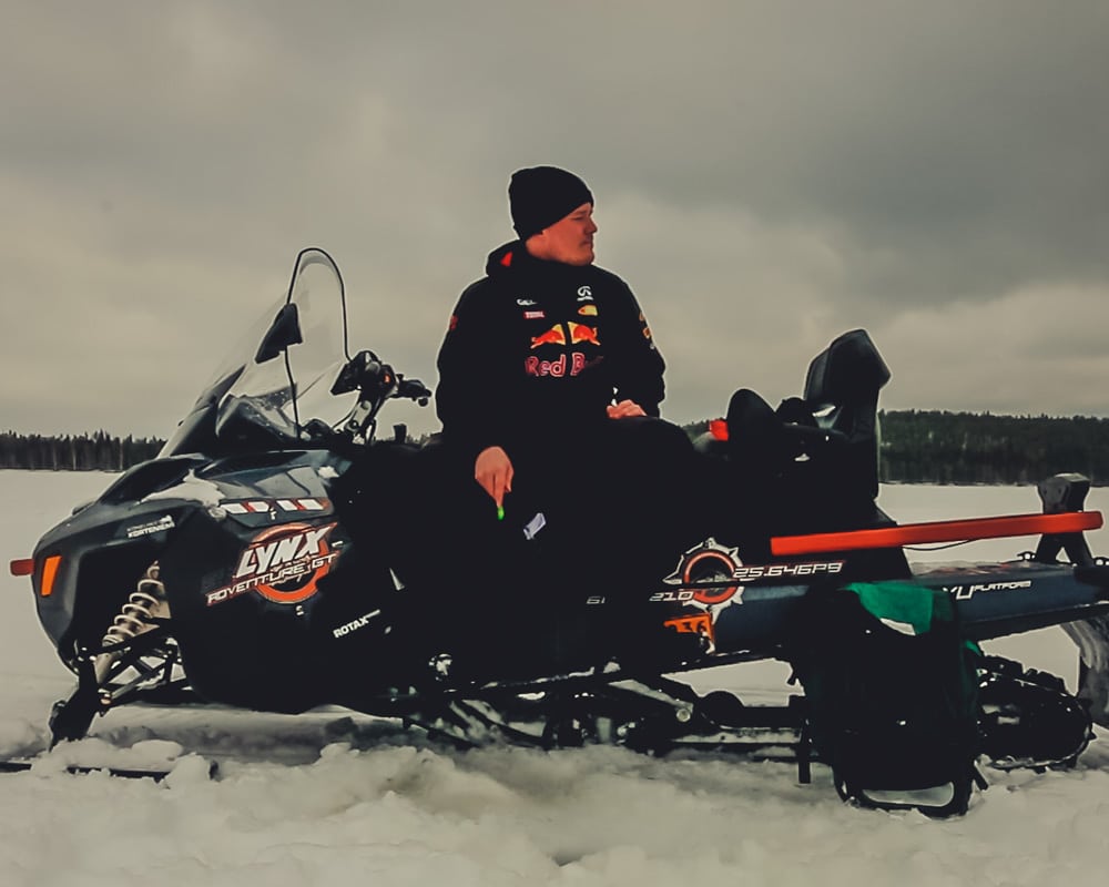 14.4.2020 Man ice fishing on top of a snowmobile.