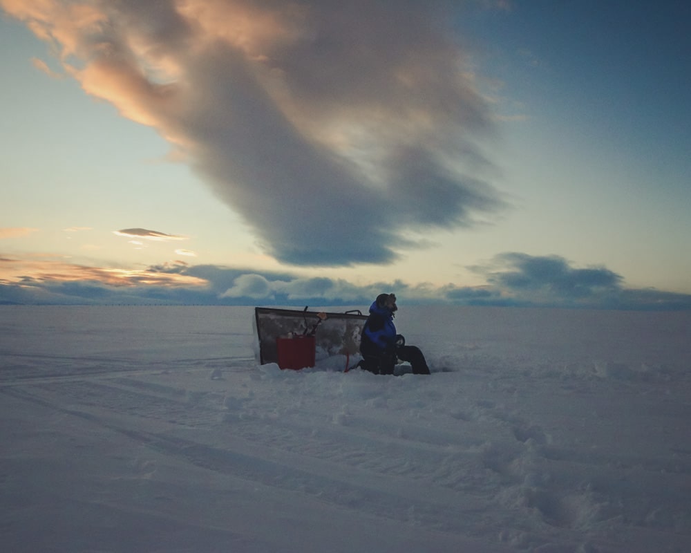 26.3.2020 Man ice fishing in Finnish Lapland.