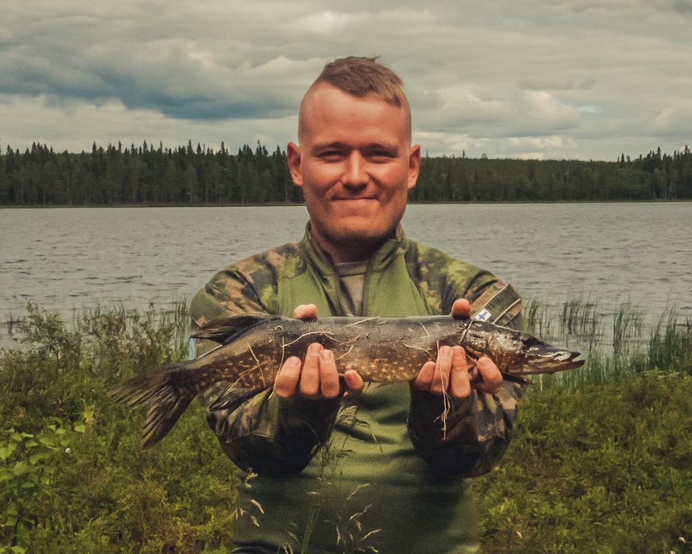 11.7.2020 Man holding a northern pike caught from remote lake.