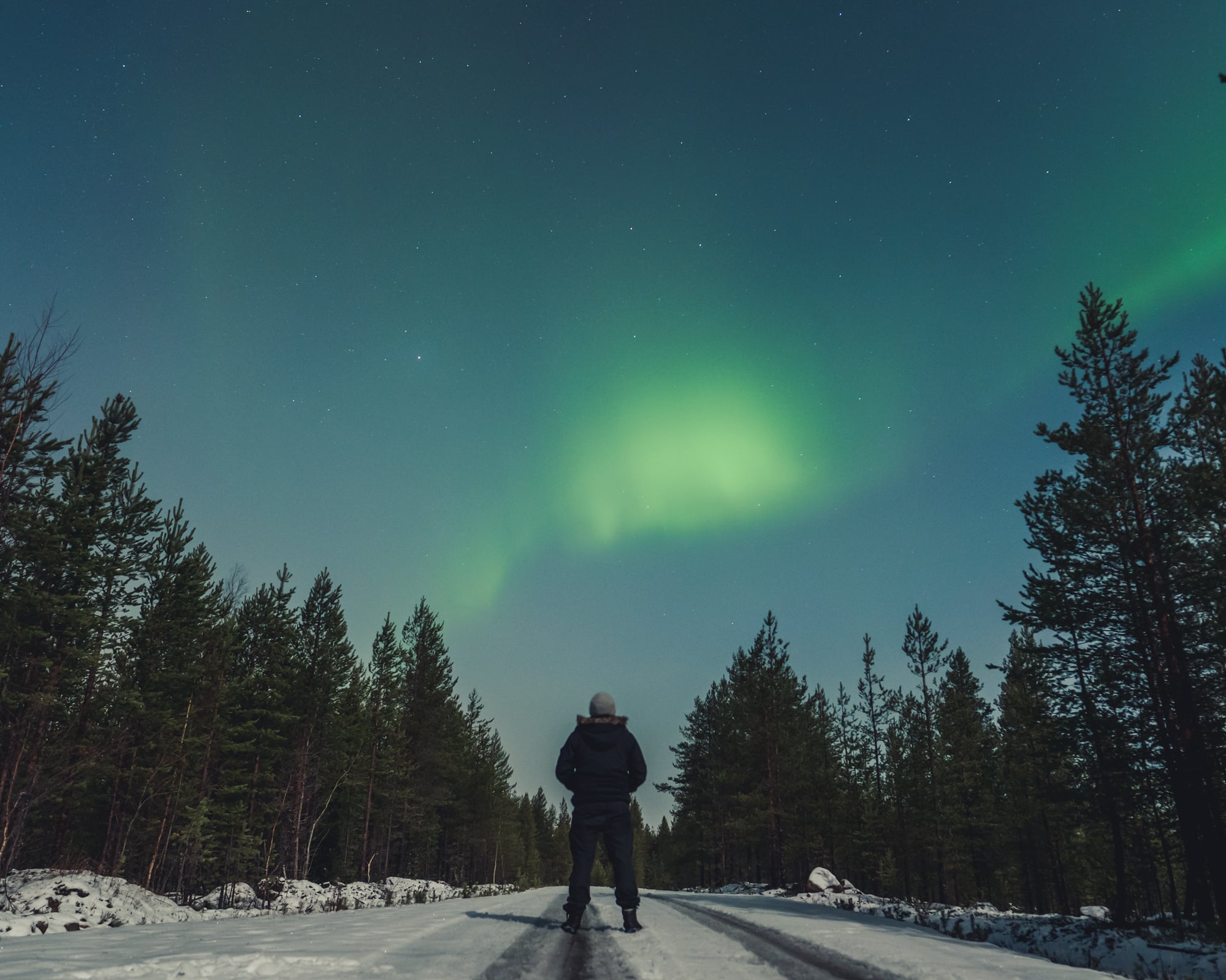 Juhani Vanhatapio standing under the northern lights.