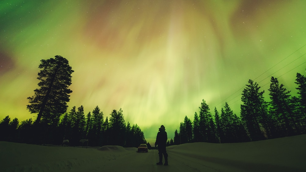 23.2.2023 Northern Lights Photographer admiring the northern lights in Lapland, Finland.