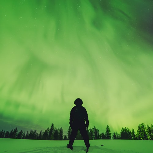 23.3.2023 Man skiing under the northern lights in Rovaniemi, Lapland.