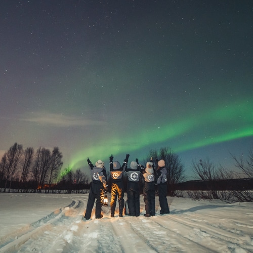 Group photo under the northern lights in Rovaniemi, Lapland.